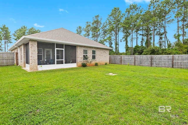 rear view of property with a yard and a sunroom