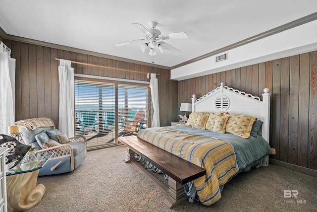 bedroom featuring carpet flooring, access to exterior, ceiling fan, and wood walls