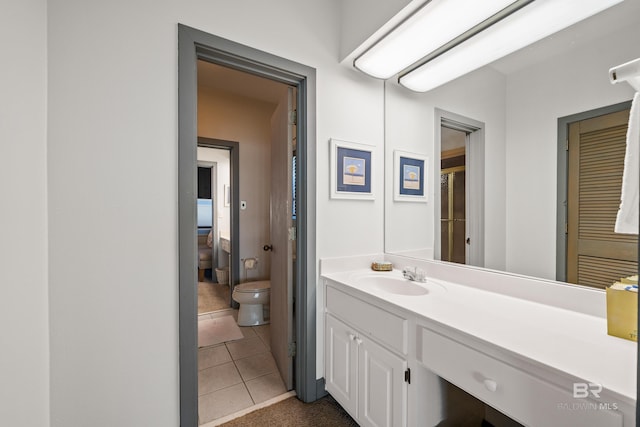 bathroom featuring tile patterned floors, vanity, and toilet