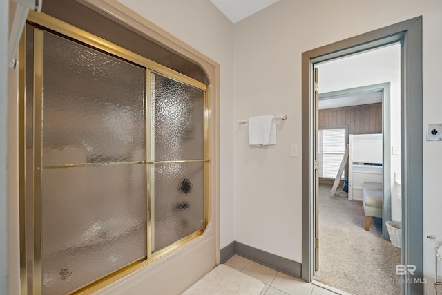 bathroom with bath / shower combo with glass door and tile patterned floors