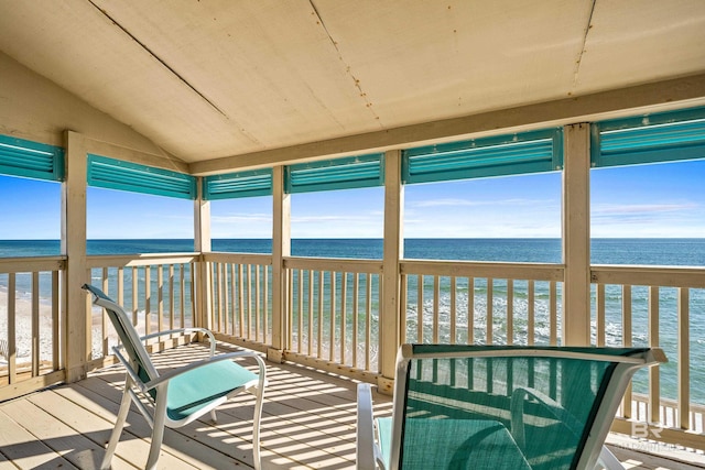 sunroom / solarium with vaulted ceiling, a beach view, and a water view