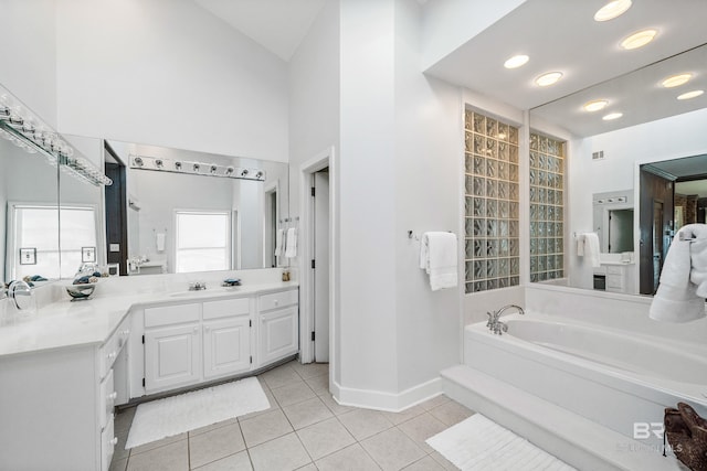 bathroom with tile patterned flooring, vanity, a tub, and a high ceiling