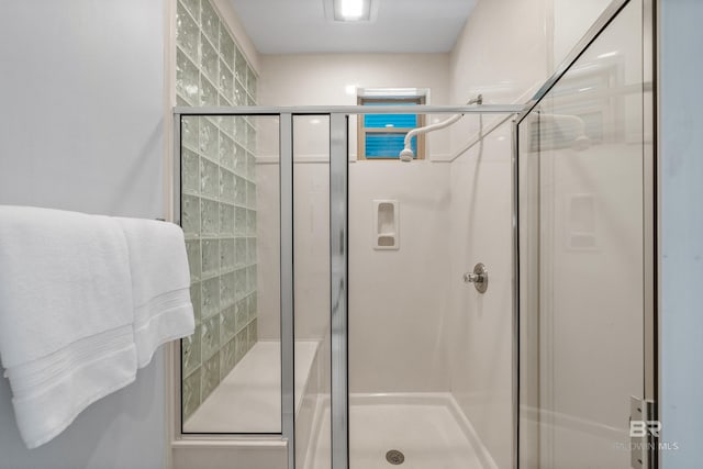 bathroom with a shower with door