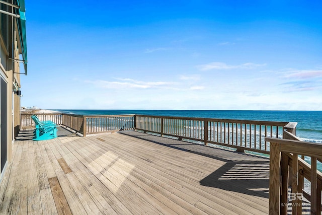 wooden terrace with a water view and a view of the beach