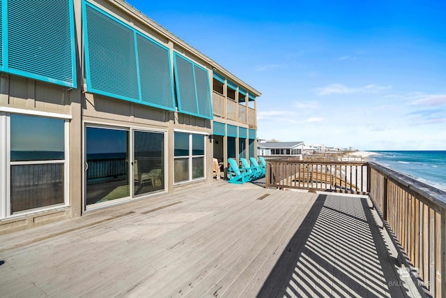 deck featuring a water view and a beach view