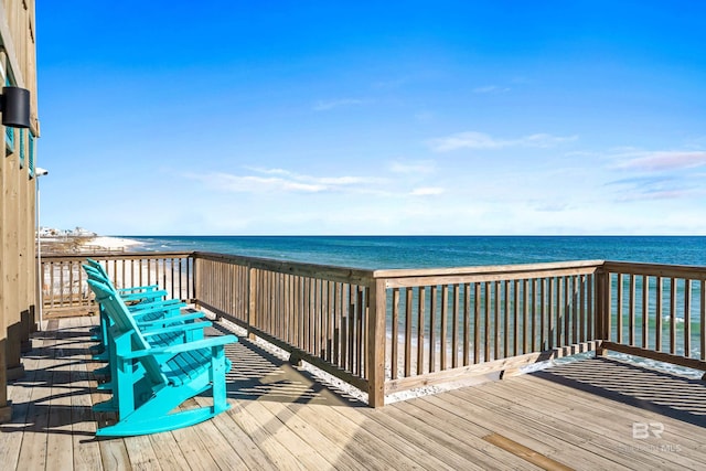 wooden deck featuring a water view and a beach view