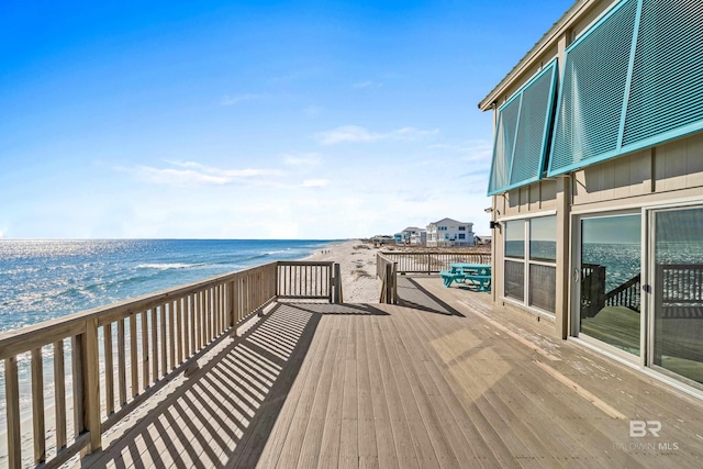 deck featuring a water view and a beach view