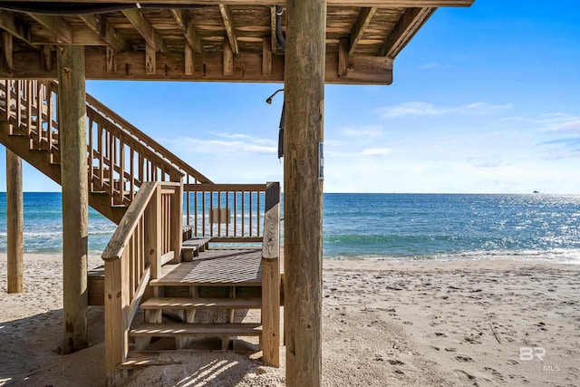 view of dock featuring a view of the beach and a water view