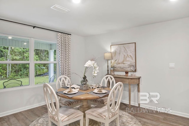 dining space featuring wood finished floors, visible vents, and baseboards