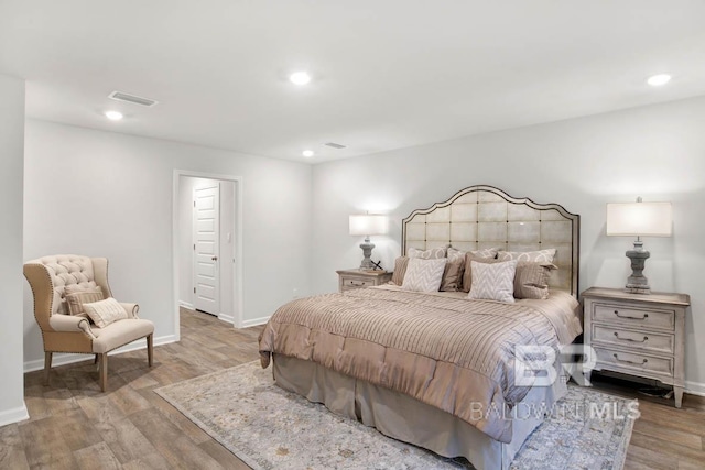 bedroom with recessed lighting, wood finished floors, and baseboards