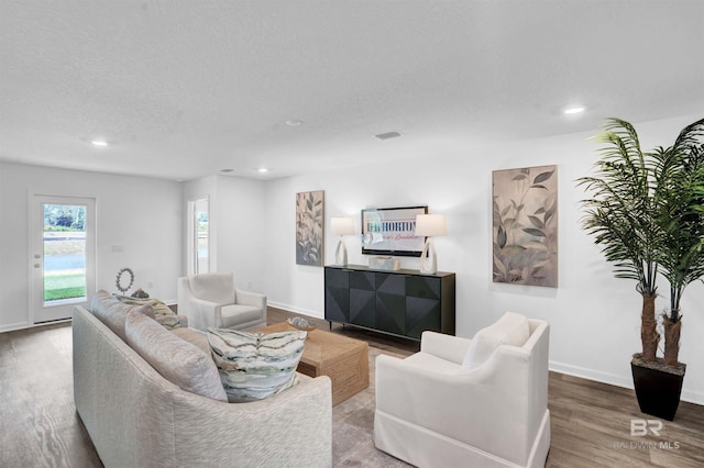 living room with recessed lighting, baseboards, and wood finished floors