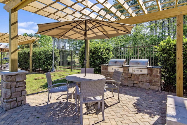 view of patio / terrace featuring fence, exterior kitchen, outdoor dining area, a pergola, and a grill