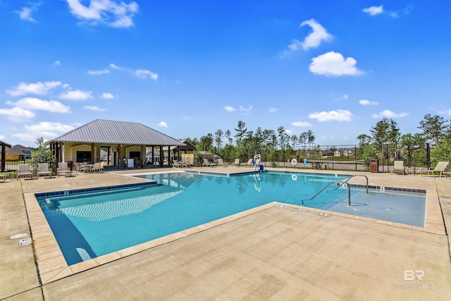 community pool with a patio area, a gazebo, and fence