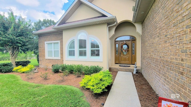 view of exterior entry with a lawn