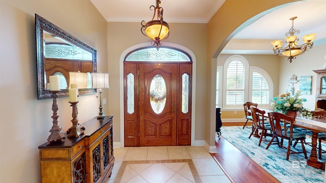 foyer entrance featuring an inviting chandelier, light hardwood / wood-style flooring, and crown molding