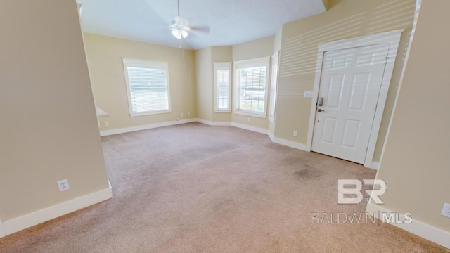 carpeted entryway with ceiling fan