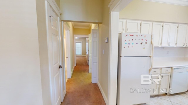 kitchen featuring white appliances, crown molding, white cabinetry, and light carpet