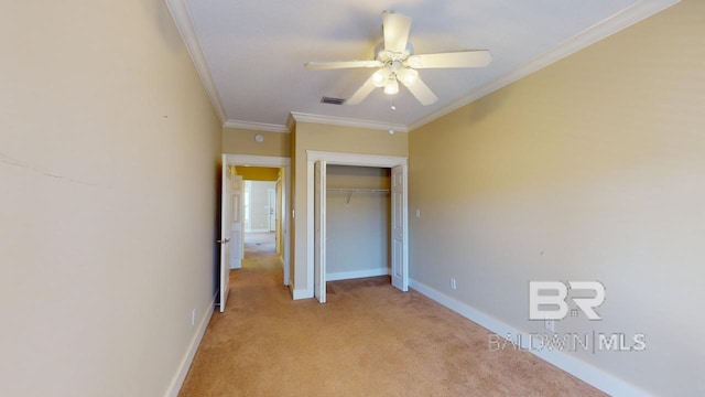 unfurnished bedroom featuring a closet, light carpet, ceiling fan, and crown molding