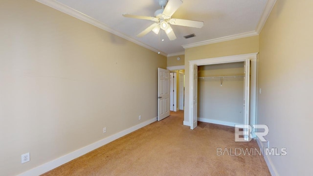 unfurnished bedroom with ceiling fan, light carpet, a closet, and crown molding