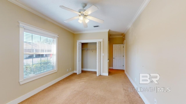 unfurnished bedroom featuring ceiling fan, crown molding, a closet, and light carpet