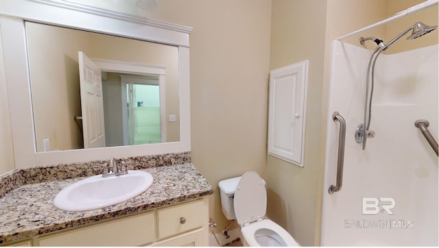 bathroom featuring toilet, walk in shower, and vanity