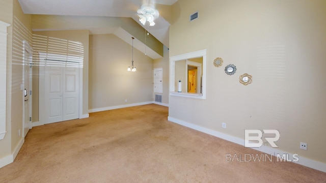 interior space with lofted ceiling, ceiling fan, and carpet