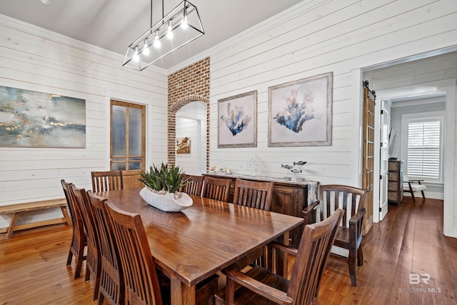 dining room with wood-type flooring and crown molding