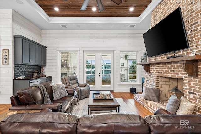 living area featuring light wood-style floors, wood ceiling, a raised ceiling, and french doors