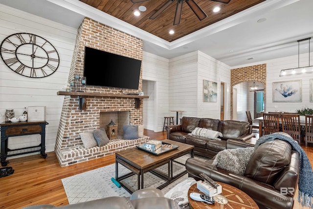 living room with wooden ceiling, recessed lighting, wood finished floors, a brick fireplace, and a raised ceiling