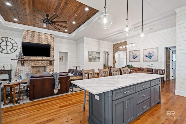 kitchen with a raised ceiling, wooden ceiling, and a kitchen bar