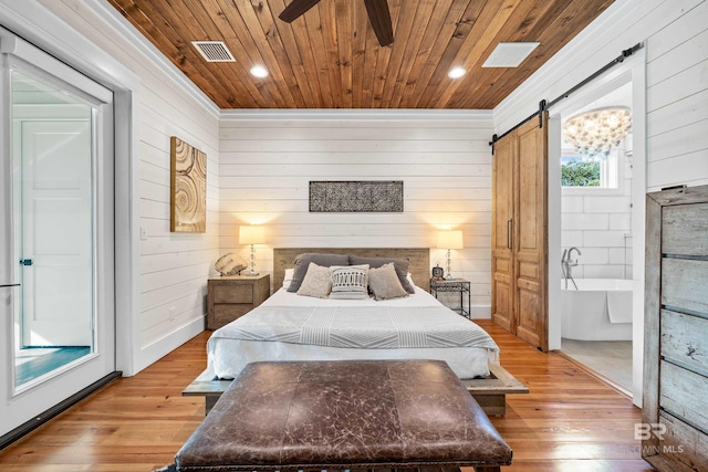 bedroom featuring visible vents, a barn door, wood ceiling, and light wood-style floors