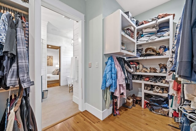 walk in closet with wood finished floors