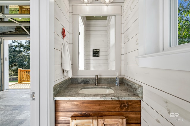 bathroom with vanity and wooden walls