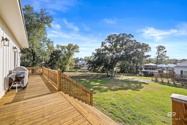 wooden terrace with a lawn and fence