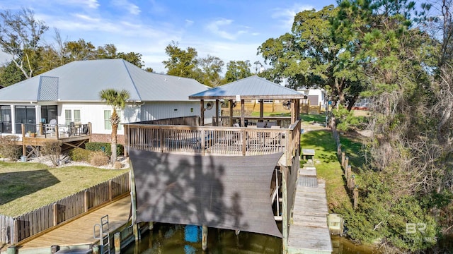 back of property with a yard, metal roof, a wooden deck, and a gazebo