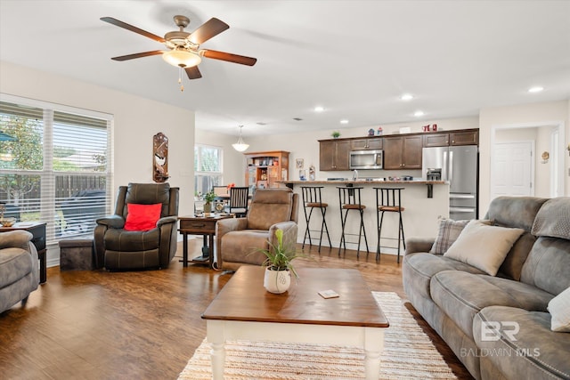 living room with dark hardwood / wood-style floors and ceiling fan