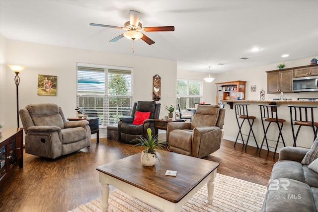 living room with ceiling fan, sink, and dark hardwood / wood-style floors