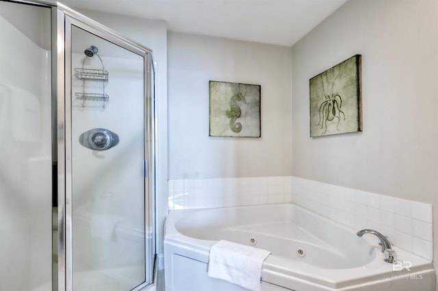 bathroom with a stall shower and a tub with jets