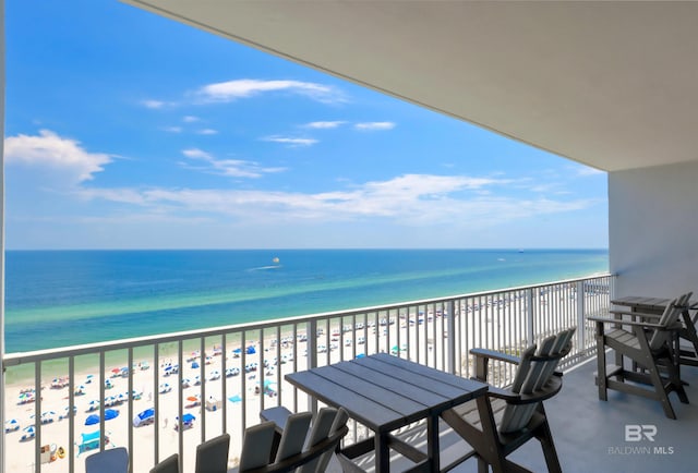 balcony featuring a water view and a beach view