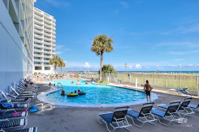 community pool with fence and a patio