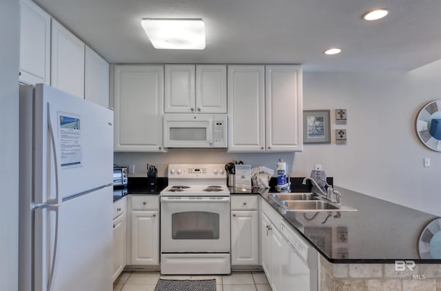 kitchen featuring white appliances, light tile patterned floors, dark countertops, a peninsula, and a sink