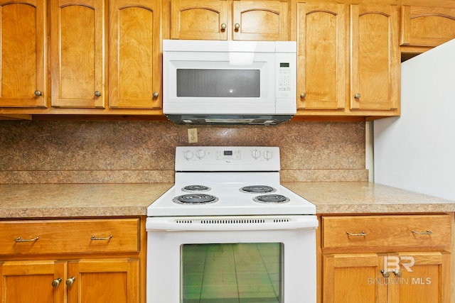 kitchen featuring tasteful backsplash and white appliances