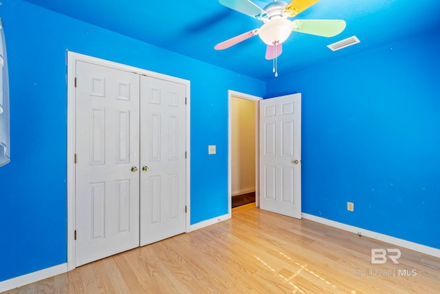 unfurnished bedroom featuring light hardwood / wood-style floors, ceiling fan, and a closet