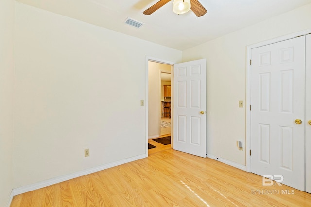 unfurnished bedroom with a closet, light wood-type flooring, and ceiling fan