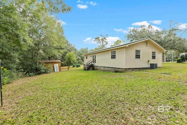 view of home's exterior with a storage shed, central AC unit, and a yard