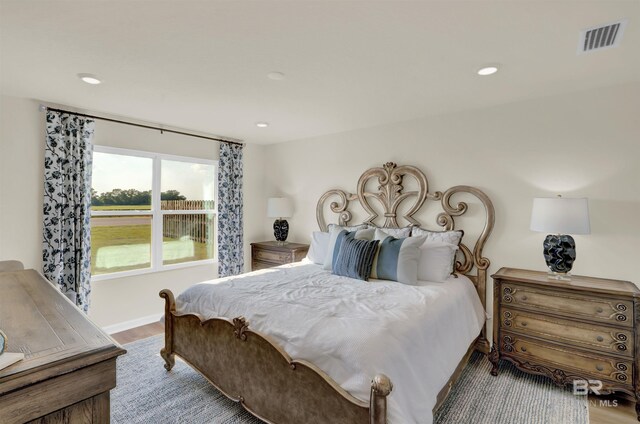 bedroom featuring baseboards, visible vents, wood finished floors, and recessed lighting