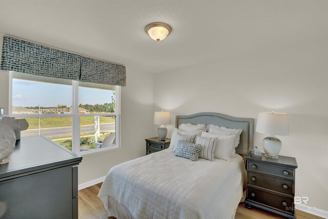 bedroom featuring baseboards and light wood-type flooring