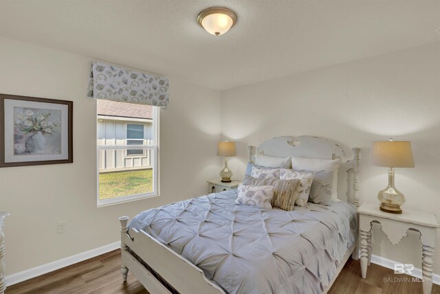 bedroom with baseboards and wood finished floors