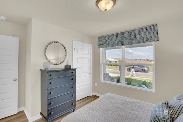 bedroom with baseboards and wood finished floors