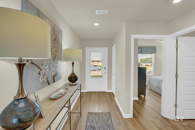 foyer entrance featuring baseboards, visible vents, light wood-style floors, and recessed lighting